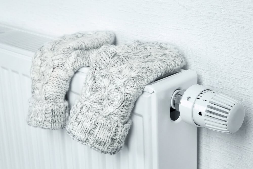 gloves on top of a wall mounted heater